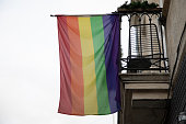 Rainbow colored flag on home windows facade building on a street in lgbt gay lesbian colors