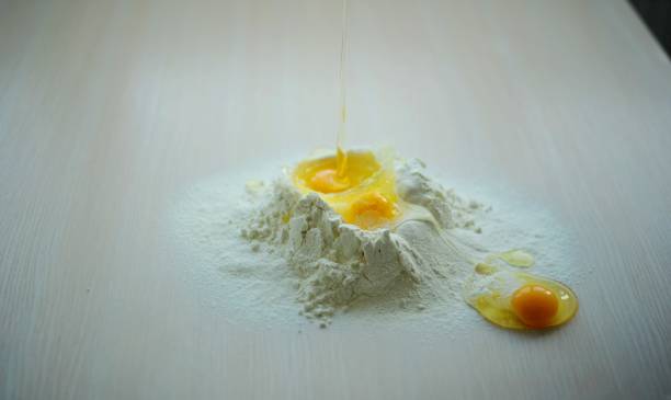 istock most beautiful video wheat flour and chicken eggs cooking baking into flour break chicken eggs fall beautifully destroying flour crumbles to sides eggs flow out sliding and spread on table slow motion 1457842220