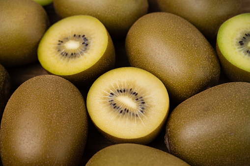 Cut a kiwi in half, showing the flesh and seeds inside. On a white background, take macro photos.