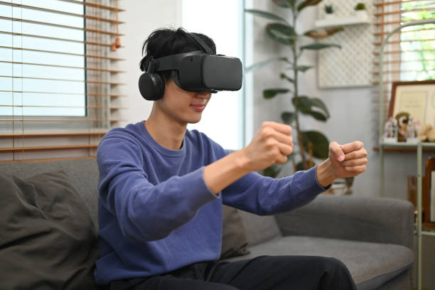 istock Young Asian man enjoy playing a driving simulation video game on virtual reality glasses. 1457844824