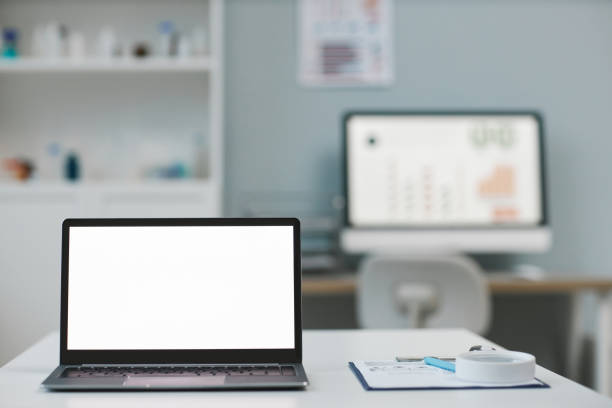 istock Laptop with blank white screen standing on desk against computer monitor 1457845510