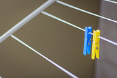 Clothing peg on washing line. Clothing pins on clothesline. Clothes pin in ukrainian colors. Blue and yellow pegs. Laundry concept. Household equipment.