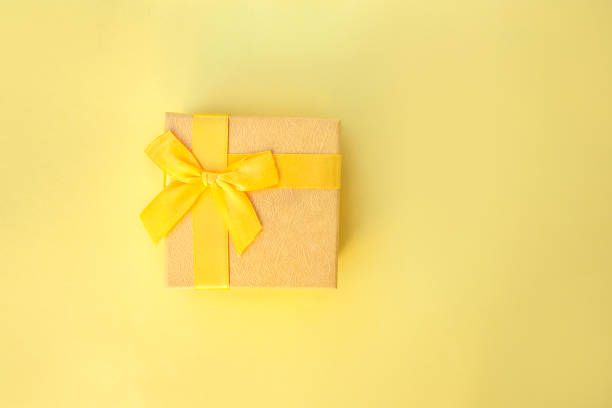 istock Beautiful gift box on yellow background 1457853246