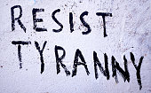 Resist Tyranny, says graffiti slogan painted on wall