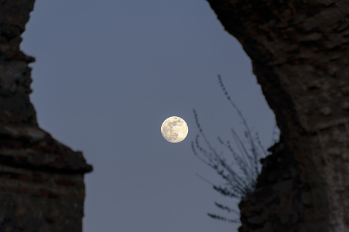 stone arches with full moon in the background at sunset