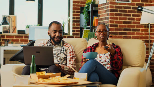 istock Happy modern people watching tv together at home 1457855238