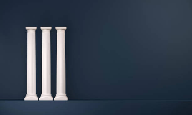 Three classical style white columns aligned on a dark blue background stock photo