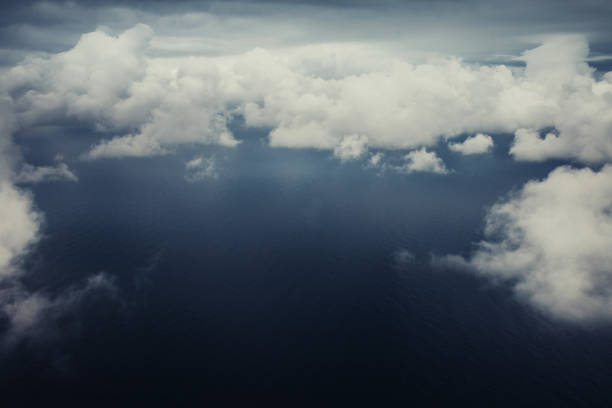 Top view of the clouds from the airplane window - storm clouds under the sun