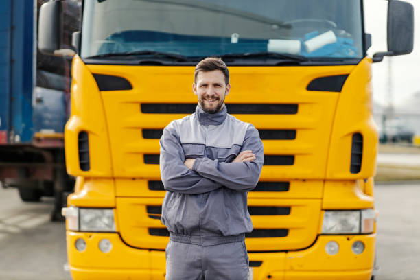 istock Portrait of a confident truck driver smiling at the camera while standing outdoors in front of the lorry. 1457873659