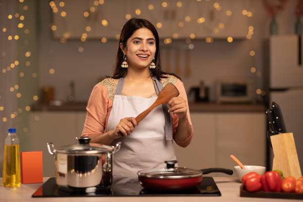 Portrait of a young woman cooking food in the kitchen stock photo stock photo