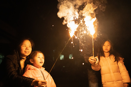 parents with children setting off fireworks