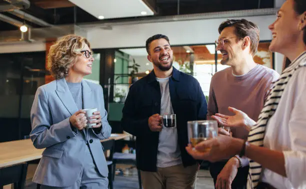 Photo of Happy colleagues having a coffee break in an office