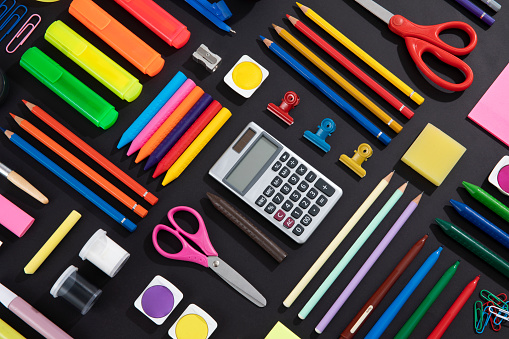 Back to school concept with school supplies knolling on black background