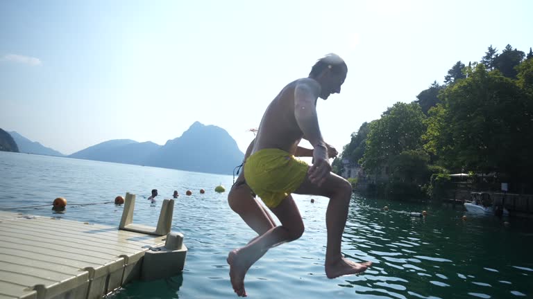 Man and woman jumping in lake, filmed with underwater housing