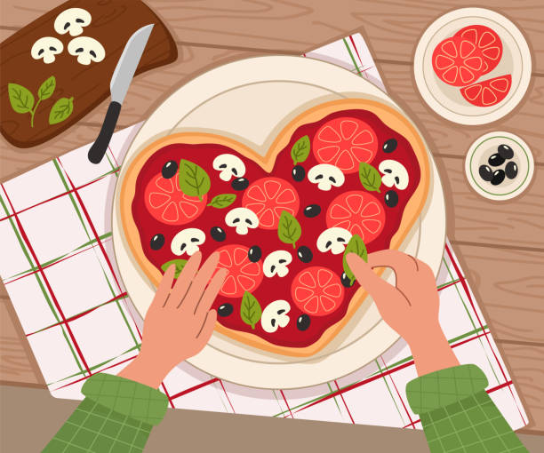 istock The process of cooking heart-shape pizza. Top table view in flat style. Knife and cutting board with vegetables, mushrooms, tomatoes, basil. Cooking food. 1457884553