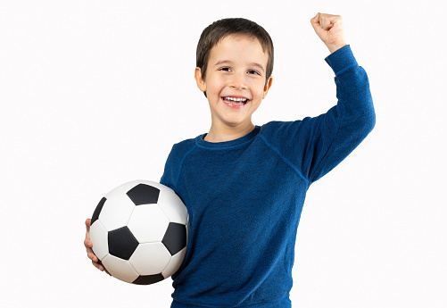 Child holding soccer football ball over isolated white background screaming proud and celebrating victory and success very excited, cheering emoticon