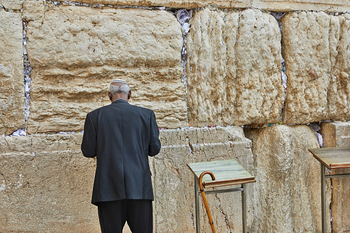 Jerusalem/Israel: July 11, 2014: Unrecognisable Orthodox Jewish man praying at the Western Wall in Jerusalem, Israel
