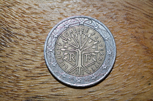 A closeup of Portugese Escudo coins on a black background