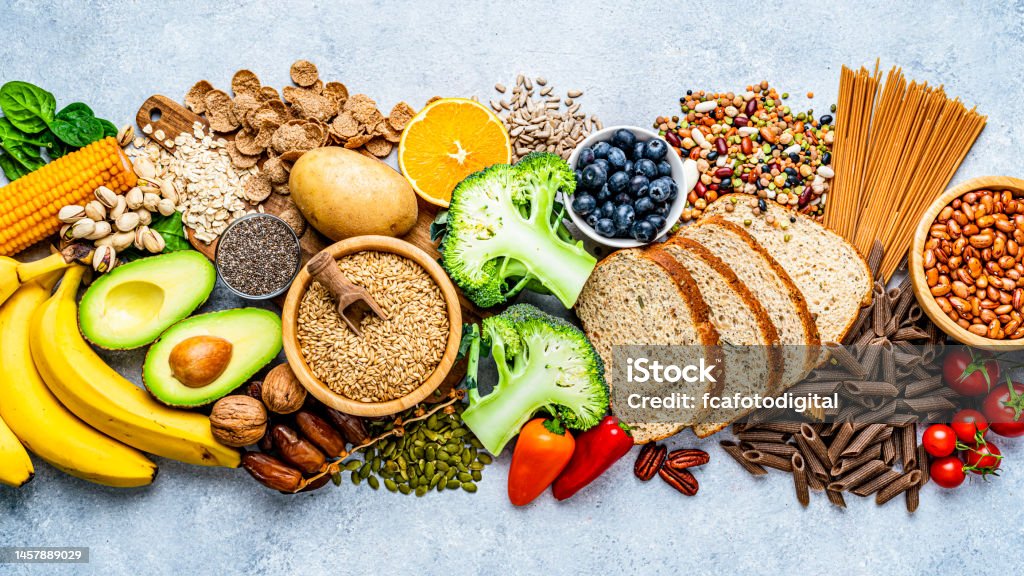 Group of food with high content of dietary fiber arranged side by side Overhead view of a large group of food with high content of dietary fiber arranged side by side. The composition includes berries, oranges, avocado, chia seeds, wholegrain bread, wholegrain pasta, whole wheat, potatoes, oat, corn, mixed beans, brazil nut, sunflower seeds, pumpkin seeds, broccoli, pistachio, banana among others. High resolution 42Mp studio digital capture taken with SONY A7rII and Zeiss Batis 40mm F2.0 CF lens Healthy Eating Stock Photo