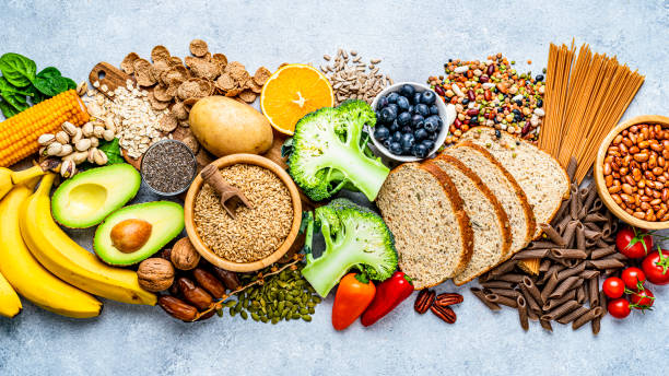 Group of food with high content of dietary fiber arranged side by side Overhead view of a large group of food with high content of dietary fiber arranged side by side. The composition includes berries, oranges, avocado, chia seeds, wholegrain bread, wholegrain pasta, whole wheat, potatoes, oat, corn, mixed beans, brazil nut, sunflower seeds, pumpkin seeds, broccoli, pistachio, banana among others. High resolution 42Mp studio digital capture taken with SONY A7rII and Zeiss Batis 40mm F2.0 CF lens dietary fiber stock pictures, royalty-free photos & images