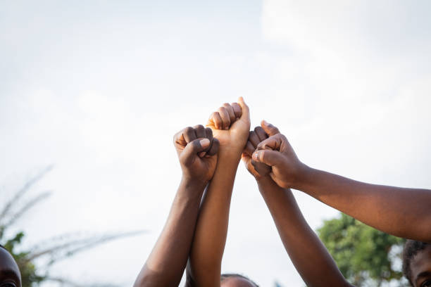 cuatro puños de africanos unidos en el cielo, foto con espacio de copia. - alertness fotografías e imágenes de stock