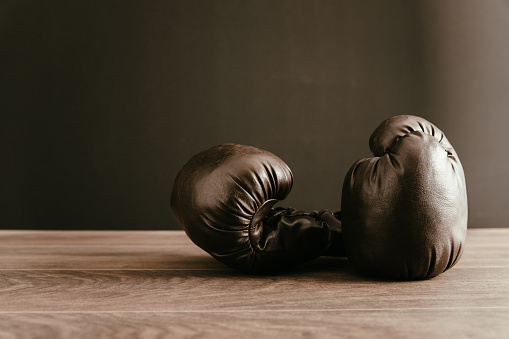 Black boxing gloves on a wooden table