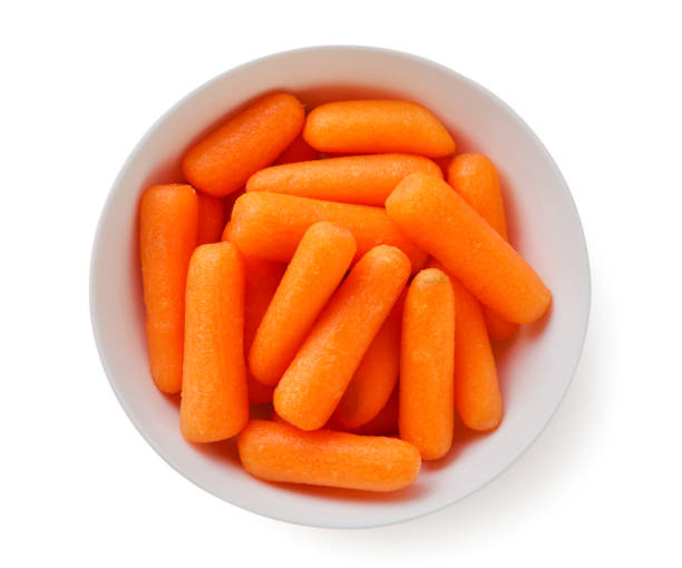 istock Peeled carrots in a plate on a white background. Top view 1457895710