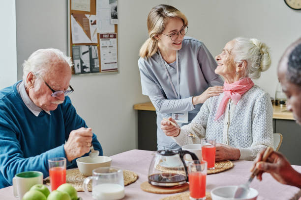 istock Caregiver helping senior people during lunch 1457898689
