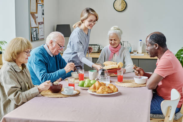 istock Caregiver serving senior people at table 1457898709