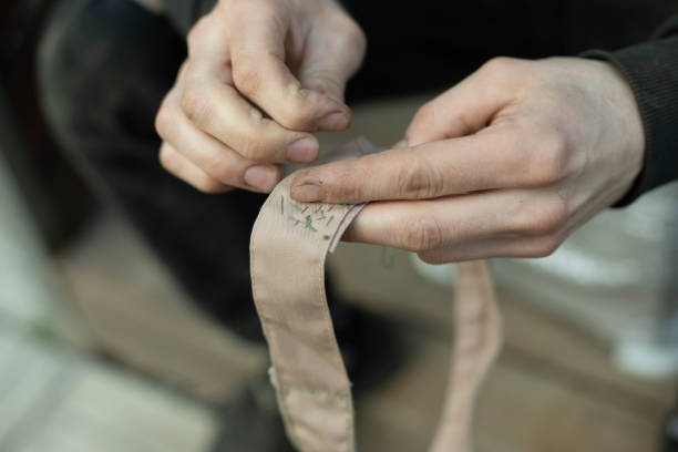 Sewing tape. Collar stitching in army. Work of weaver.