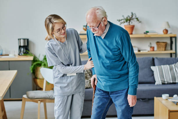 istock Caregiver helping senior man to walk 1457905931