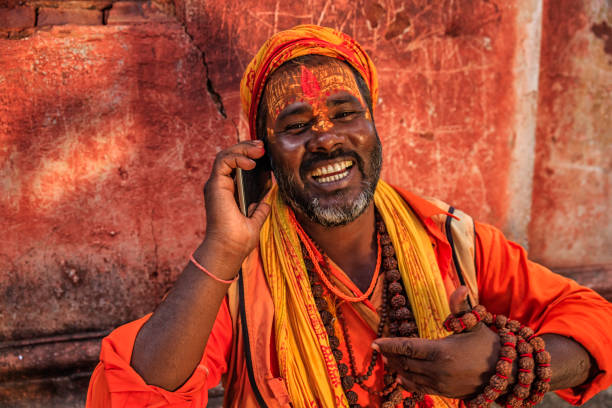 sadhu - indyjski święty za pomocą telefonu komórkowego - indian culture guru sadhu hinduism zdjęcia i obrazy z banku zdjęć