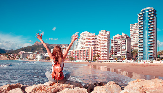 Happy traveler woman tourist enjoying beautiful city landscape and tropical beach in Calpe,  Alicante province in Spain, coasta blanca