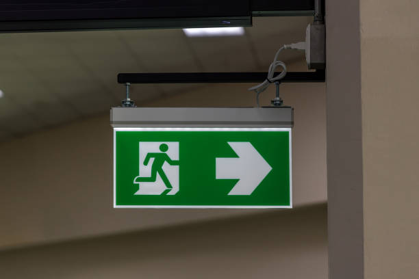 istock Green emergency exit sign showing the way to escape. Fire exit in the building. 1457908325