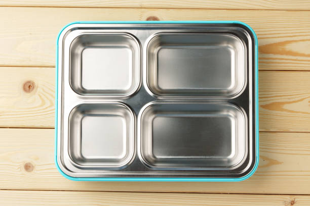 Metal lunch box with compartments on wooden background top view