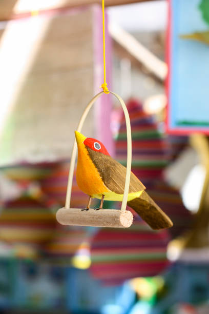 Colorful toy bird in sharp focus foreground Typical brazilian wooden toy made from a material called "miriti". cirio de nazare stock pictures, royalty-free photos & images