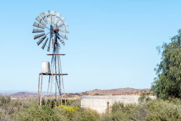 istock Typical Karoo landscape with a windmill, water tank and dam 1457913170