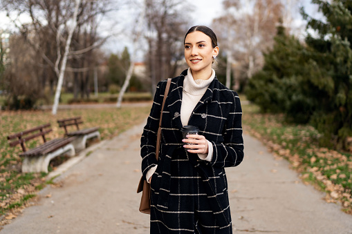 Beautiful businesswoman walking in the public park