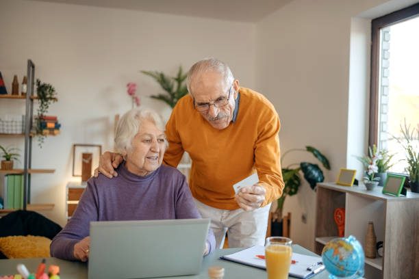 istock Old couple shopping online at home using laptop 1457914683