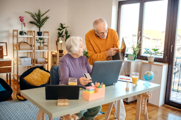 istock Old couple shopping online at home using laptop 1457915649