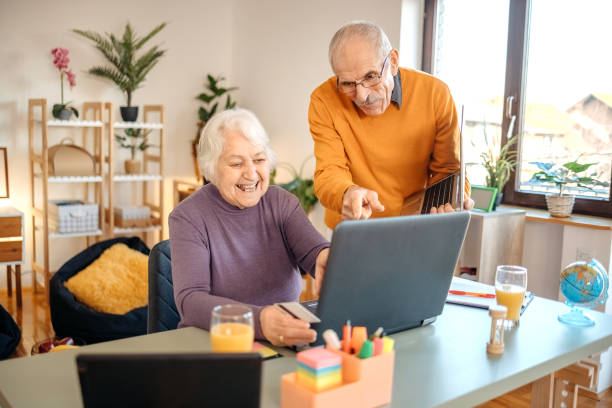 istock Old couple shopping online at home using laptop 1457915801