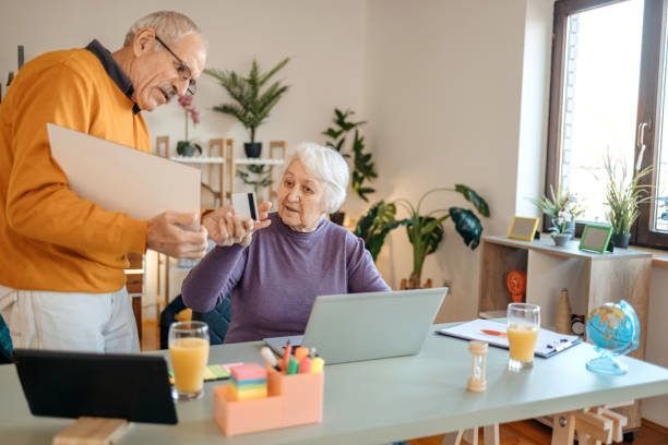istock Old couple shopping online at home 1457915982