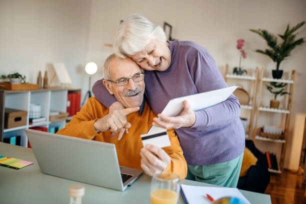 istock Old couple shopping online at home 1457916257