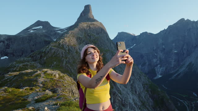 Woman making selfie while hiking in Norwegian mountains