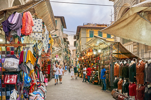 Florence, Italy - September 05, 2022: Pedestrians in the alleys at the Loggia Mercato Nuovo. Many traders sell leather goods and clothing here.