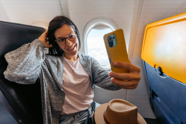 istock Young Woman Taking Selfies In An Airplane 1457923940
