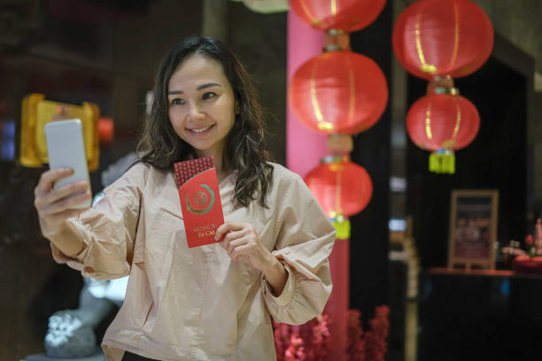 istock Chinese Woman Holding a Red Angpao Envelope During Video Call 1457925376
