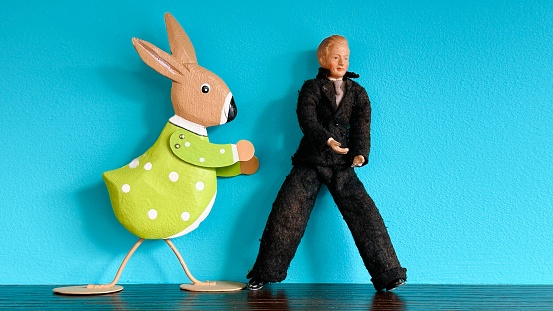 Vintage puppet man and a green toy rabbit
