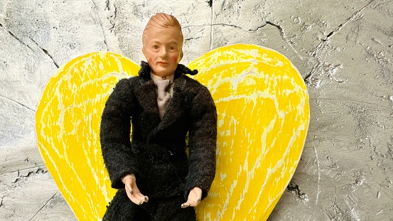 Vintage puppet, black dressed man on yellow heart shape