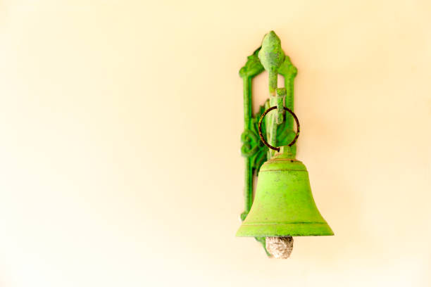 close up photograph of a green bell on a wall